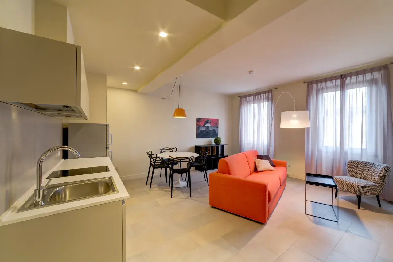 Panoramic view of the spacious and light-filled living room in a Bilo Deluxe apartment.