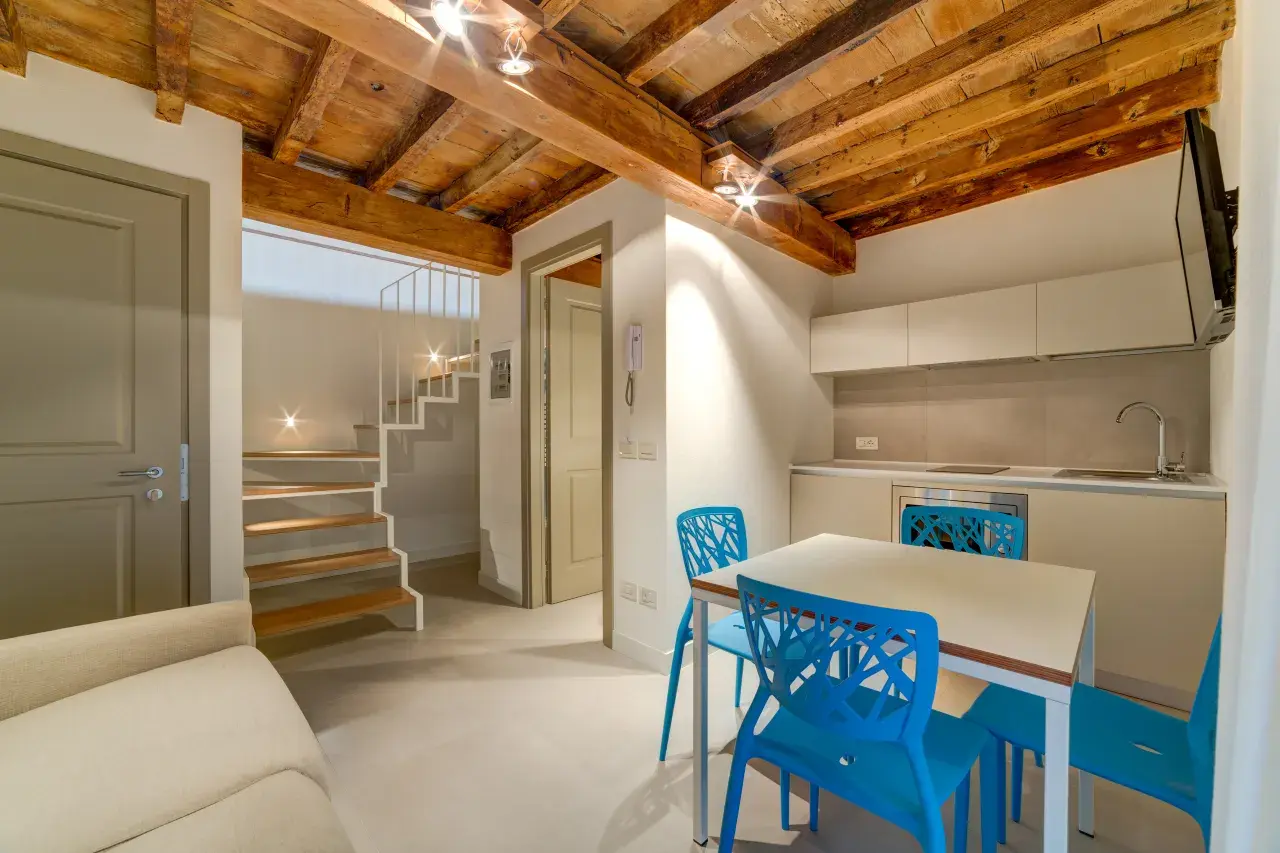 Lower-floor living room with kitchen and dining table for 4 - Bilo Deluxe.